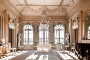 Tom slottssalong, med stolar som pekar mot altaret och stor kristallkrona som hänger i taket